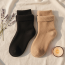 Meias de dormir NINHO nas cores preta e bege sobre linho claro, com lavanda e vela